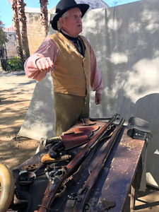 Man demonstrating period rifles at the Alamo.